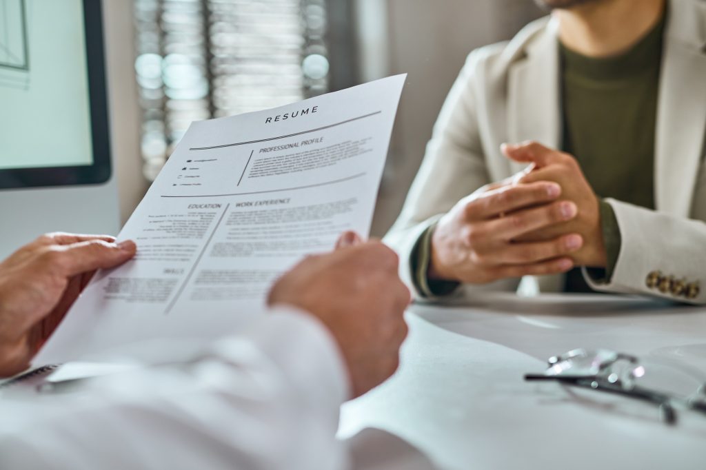 Close-up of businessman reading candidate's CV on a job interview.